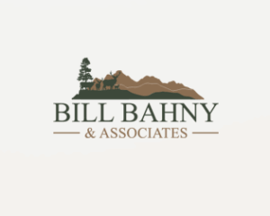 Logo for Bill Bahny & Associates featuring silhouettes of a tree, two elk, and mountains above the business name in green and brown tones—perfect for those seeking hunting land or ranch homes.